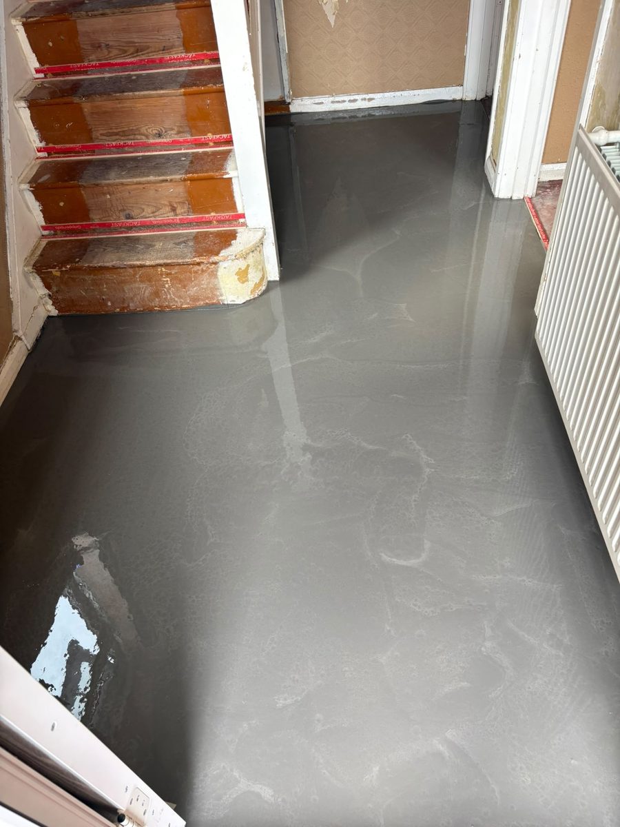 The same hallway floor after self-levelling compound has been poured, smooth and flat