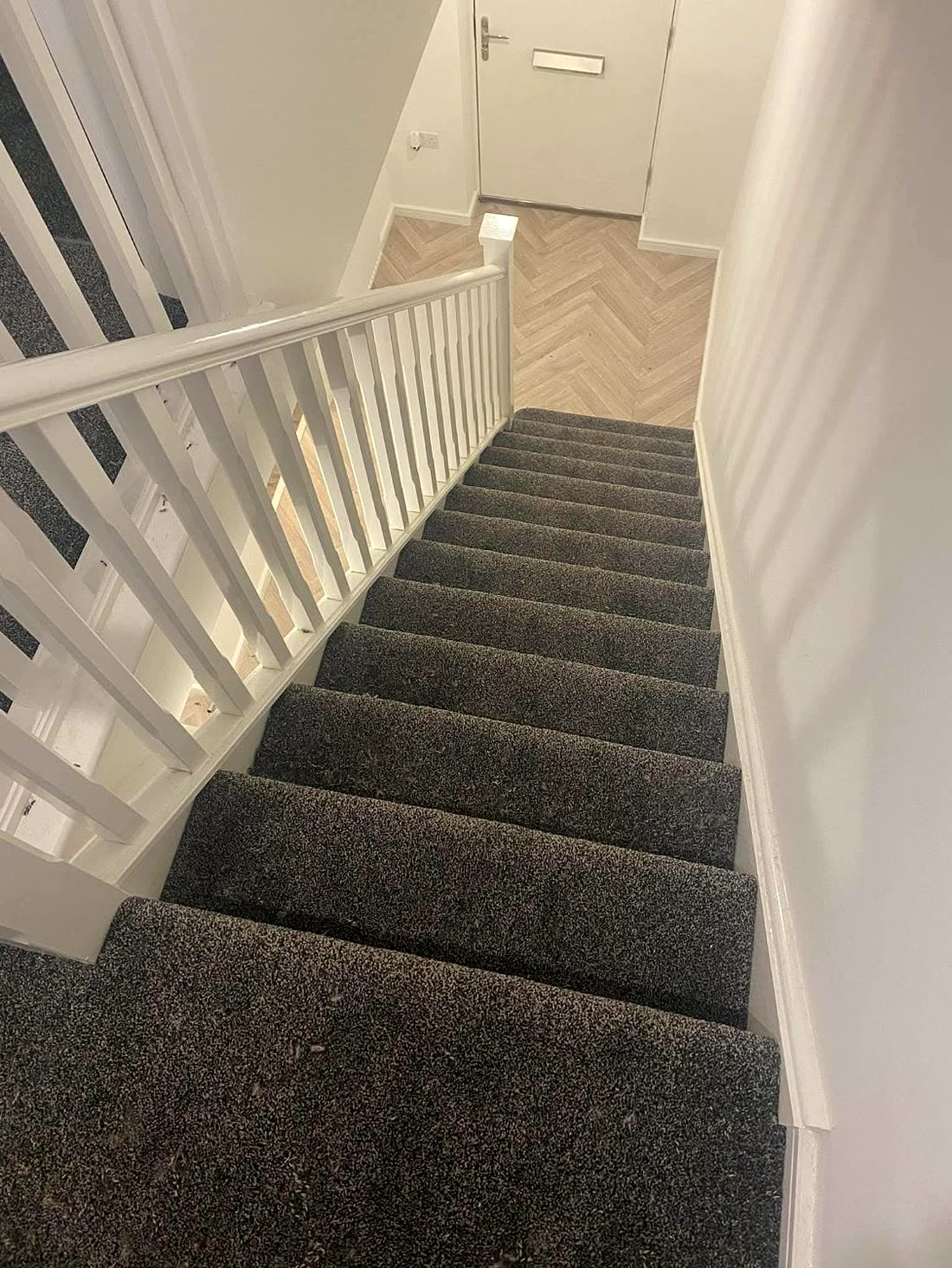 Carpet up the stairs with herringbone vinyl at the bottom