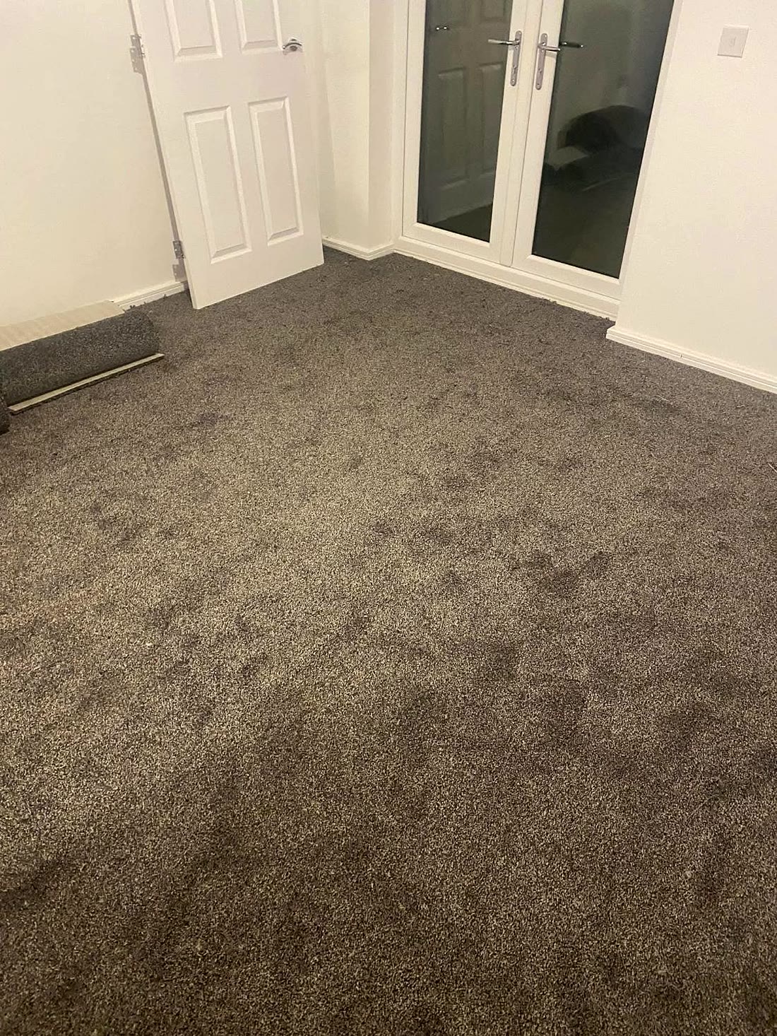 Dark carpet in a bedroom with patio doors